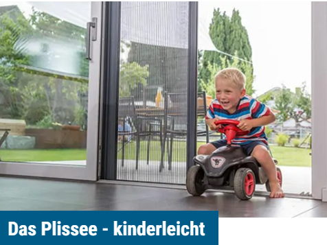 Ein Kind kommt mit der Bobbycar von der Terrasse ins Haus gefahren der Insektenschutz als Plissee ist halb geschlossen