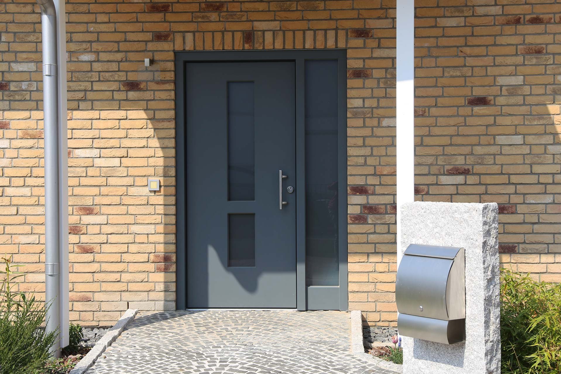 moderner Hauseingang mit grauer Haustür